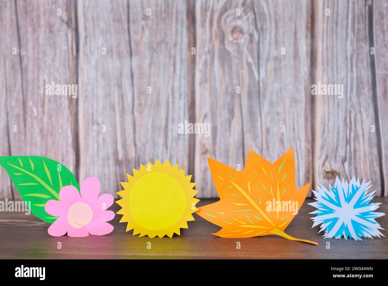 Decorazioni con icone delle quattro stagioni su sfondo in legno. Foto Stock