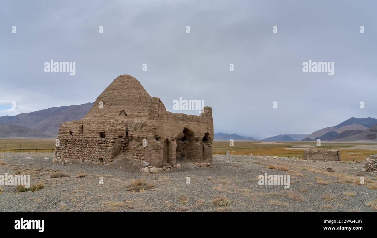 Vista panoramica delle rovine dell'antica strada della seta caravanserraglio o tomba cinese tra le montagne di Bash Gumbaz, Gorno-Badakshan, Tagikistan Pamir Foto Stock