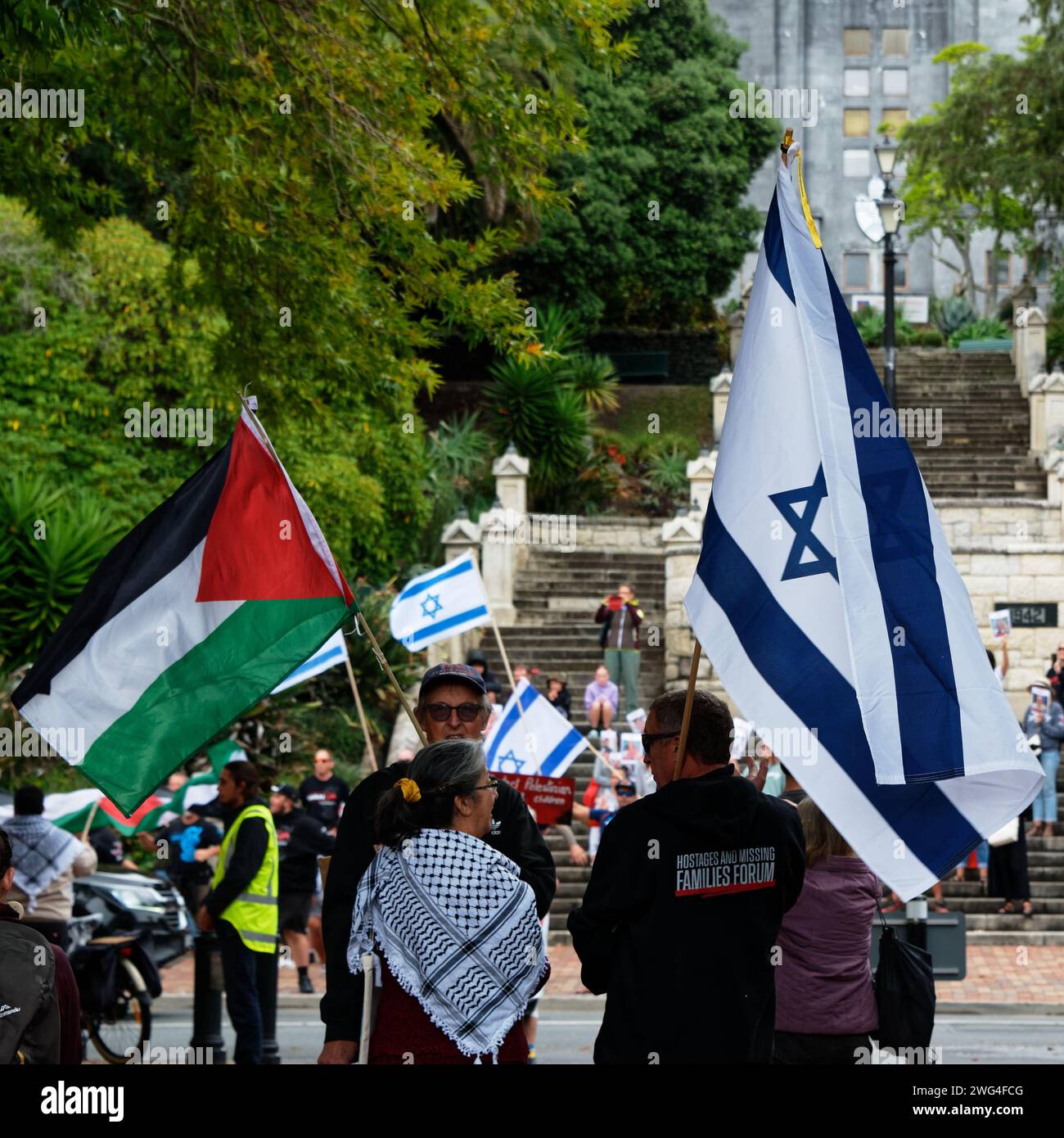 Nelson, nuova Zelanda, 3 febbraio 2024, due manifestanti, uno con bandiera palestinese, l'altro con bandiera israeliana, stanno insieme durante le proteste Foto Stock