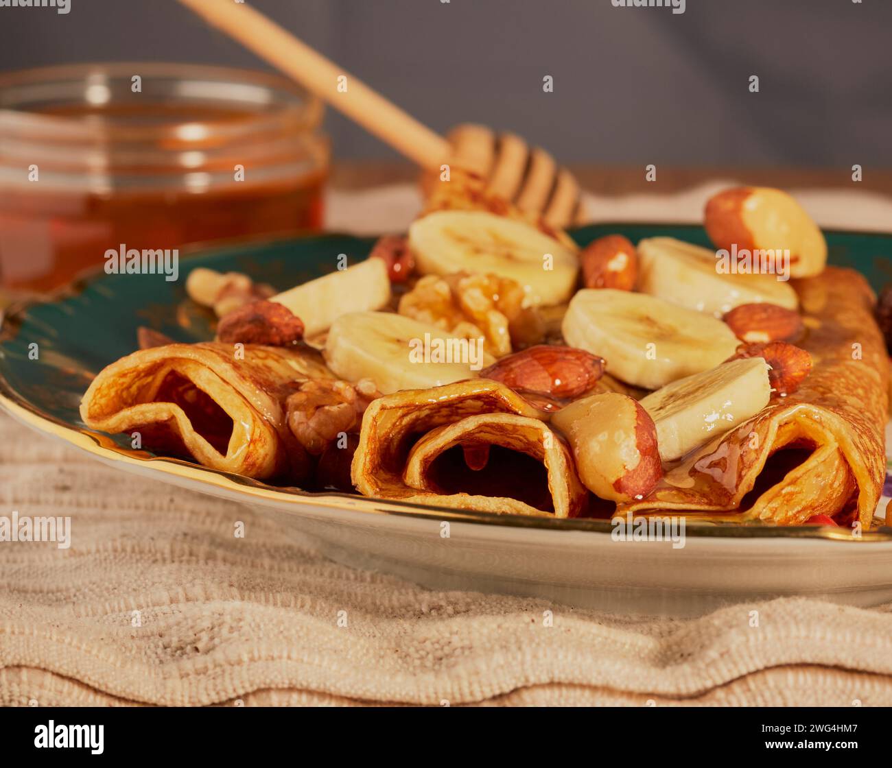 Frittelle fresche con banana e noci miste e condite con miele. Foto Stock