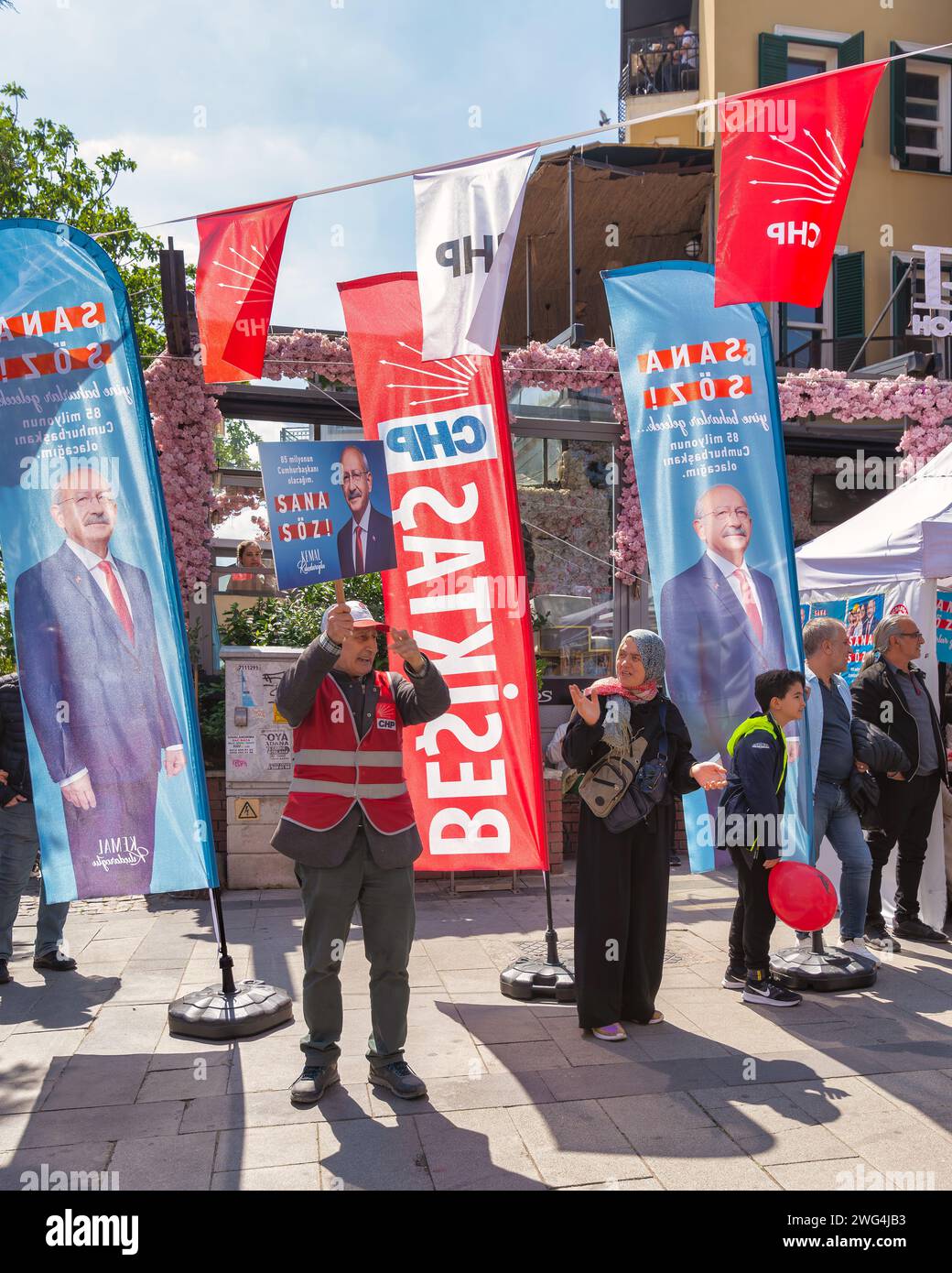 Istanbul, Turchia - Maggio 13 2023: Uomo che sventola un grande poster con Kemal Kilicdaroglu foto di fronte al chiosco del Partito popolare Repubblicano nel quartiere di Ortakoy durante le elezioni del 2023 Foto Stock