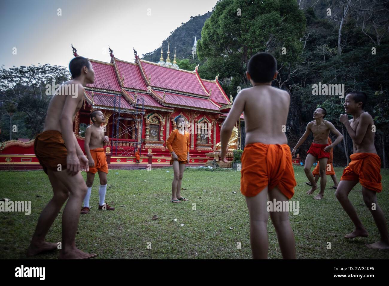 I monaci locali e birmani giocano a calcio nel tardo pomeriggio al tempio di Wat Tham Pla. Il Wat Tham Pla (Tempio dei pesci della grotta) è anche chiamato il "Tempio delle scimmie" per gli abitanti thailandesi, situato a 16 chilometri da Mae Sai, la città più settentrionale della Thailandia. Foto Stock