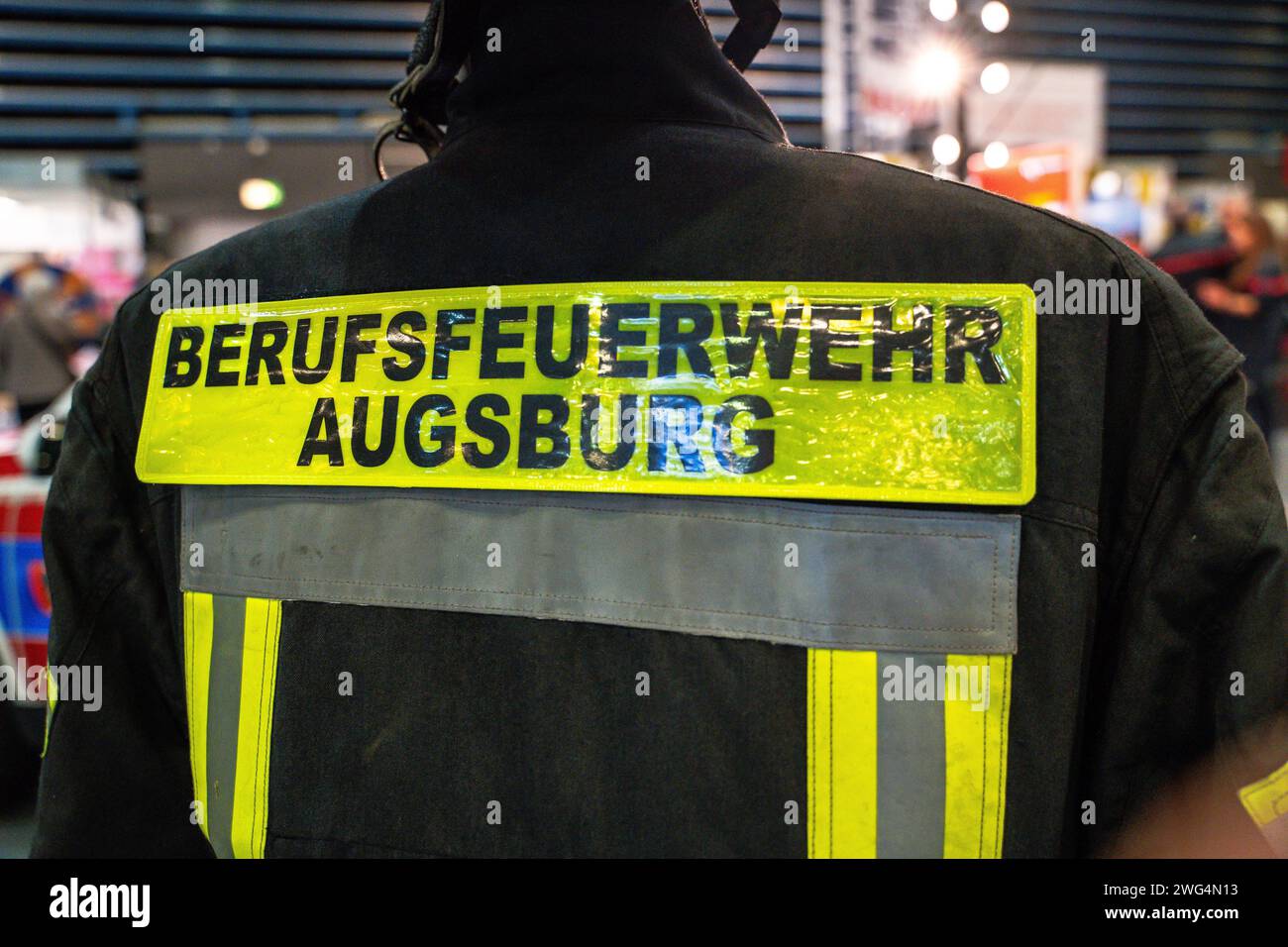 Augusta, Baviera, Germania - 2 febbraio 2024: Stand dei vigili del fuoco di Augusta alla fiera AFA. Vigili del fuoco con camion antincendio, abbigliamento protettivo e uniforme *** Messestand der Berufsfeuerwehr Augsburg auf der AFA-Messe. Feuerwehr mit Feuerwehrauto, Schutzkleidung und Uniform Foto Stock