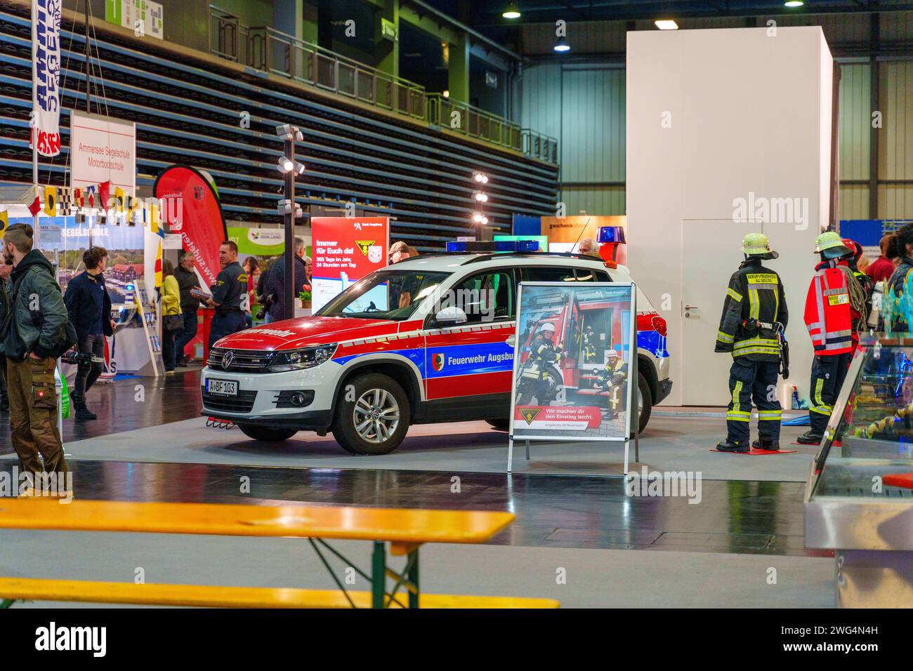 Augusta, Baviera, Germania - 2 febbraio 2024: Stand dei vigili del fuoco di Augusta alla fiera AFA. Vigili del fuoco con camion antincendio, abbigliamento protettivo e uniforme *** Messestand der Berufsfeuerwehr Augsburg auf der AFA-Messe. Feuerwehr mit Feuerwehrauto, Schutzkleidung und Uniform Foto Stock