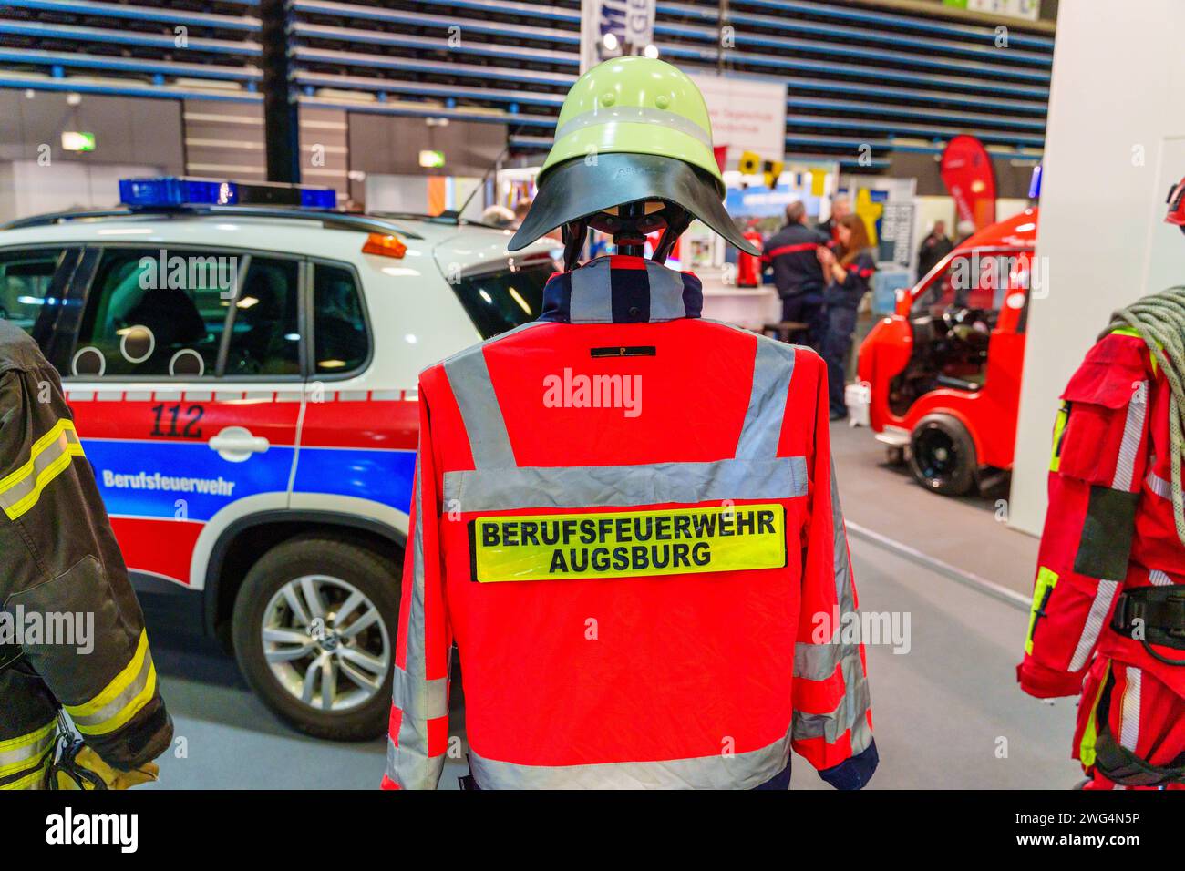 Augusta, Baviera, Germania - 2 febbraio 2024: Stand dei vigili del fuoco di Augusta alla fiera AFA. Vigili del fuoco con camion antincendio, abbigliamento protettivo e uniforme *** Messestand der Berufsfeuerwehr Augsburg auf der AFA-Messe. Feuerwehr mit Feuerwehrauto, Schutzkleidung und Uniform Foto Stock