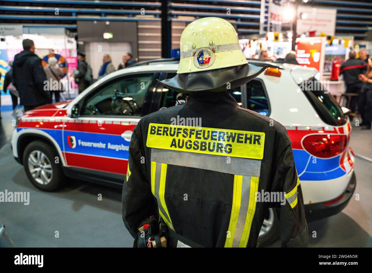 Augusta, Baviera, Germania - 2 febbraio 2024: Stand dei vigili del fuoco di Augusta alla fiera AFA. Vigili del fuoco con camion antincendio, abbigliamento protettivo e uniforme *** Messestand der Berufsfeuerwehr Augsburg auf der AFA-Messe. Feuerwehr mit Feuerwehrauto, Schutzkleidung und Uniform Foto Stock
