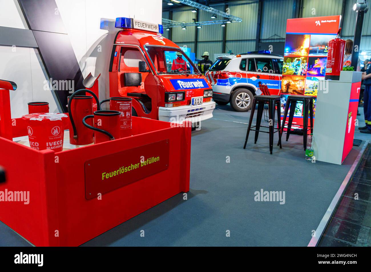 Augusta, Baviera, Germania - 2 febbraio 2024: Stand dei vigili del fuoco di Augusta alla fiera AFA. Vigili del fuoco con camion antincendio, abbigliamento protettivo e uniforme *** Messestand der Berufsfeuerwehr Augsburg auf der AFA-Messe. Feuerwehr mit Feuerwehrauto, Schutzkleidung und Uniform Foto Stock