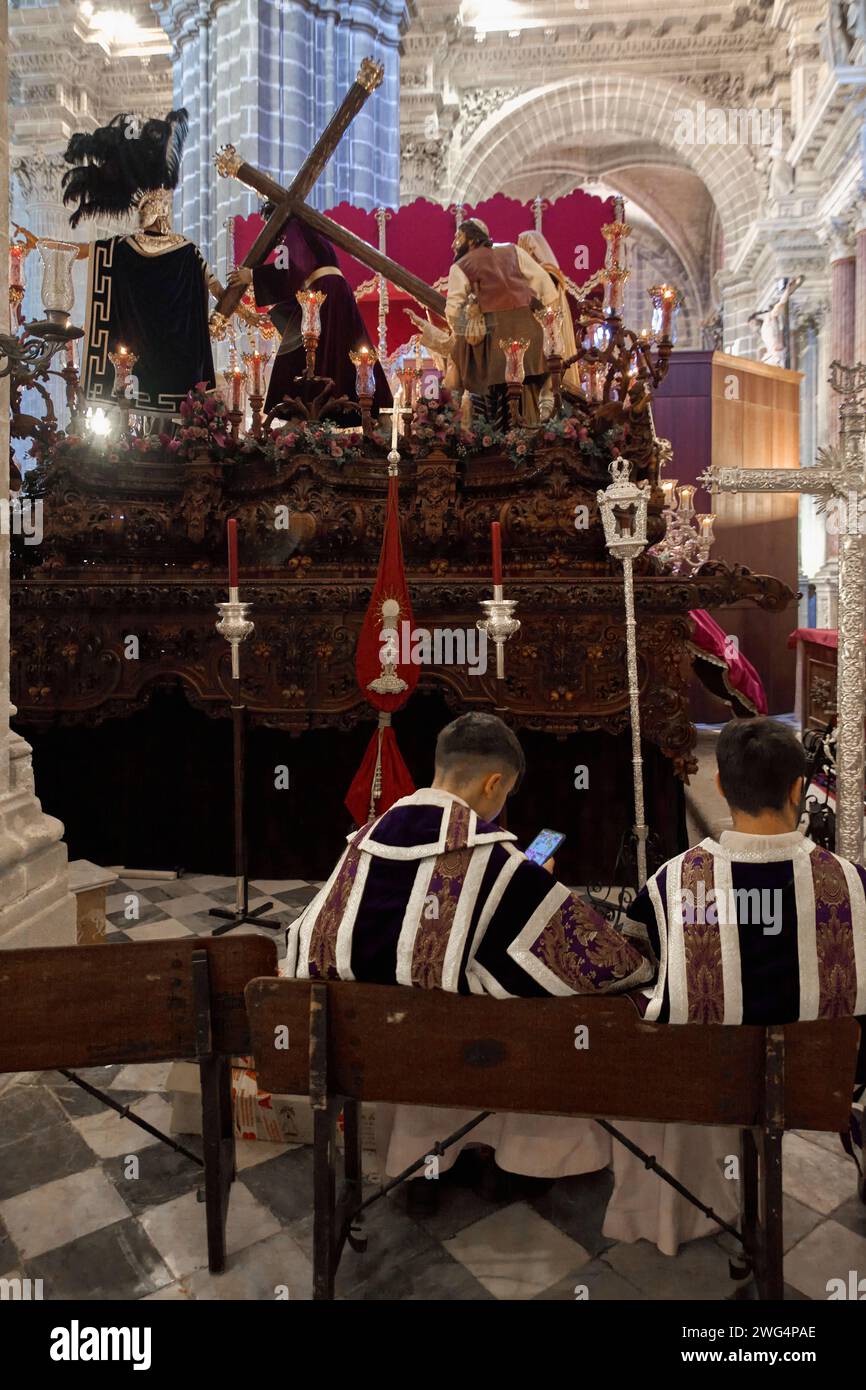 Jerez de la Frontera, Spagna - 3 febbraio 2024: Ragazzi ingrossati in smartphone in Chiesa Foto Stock