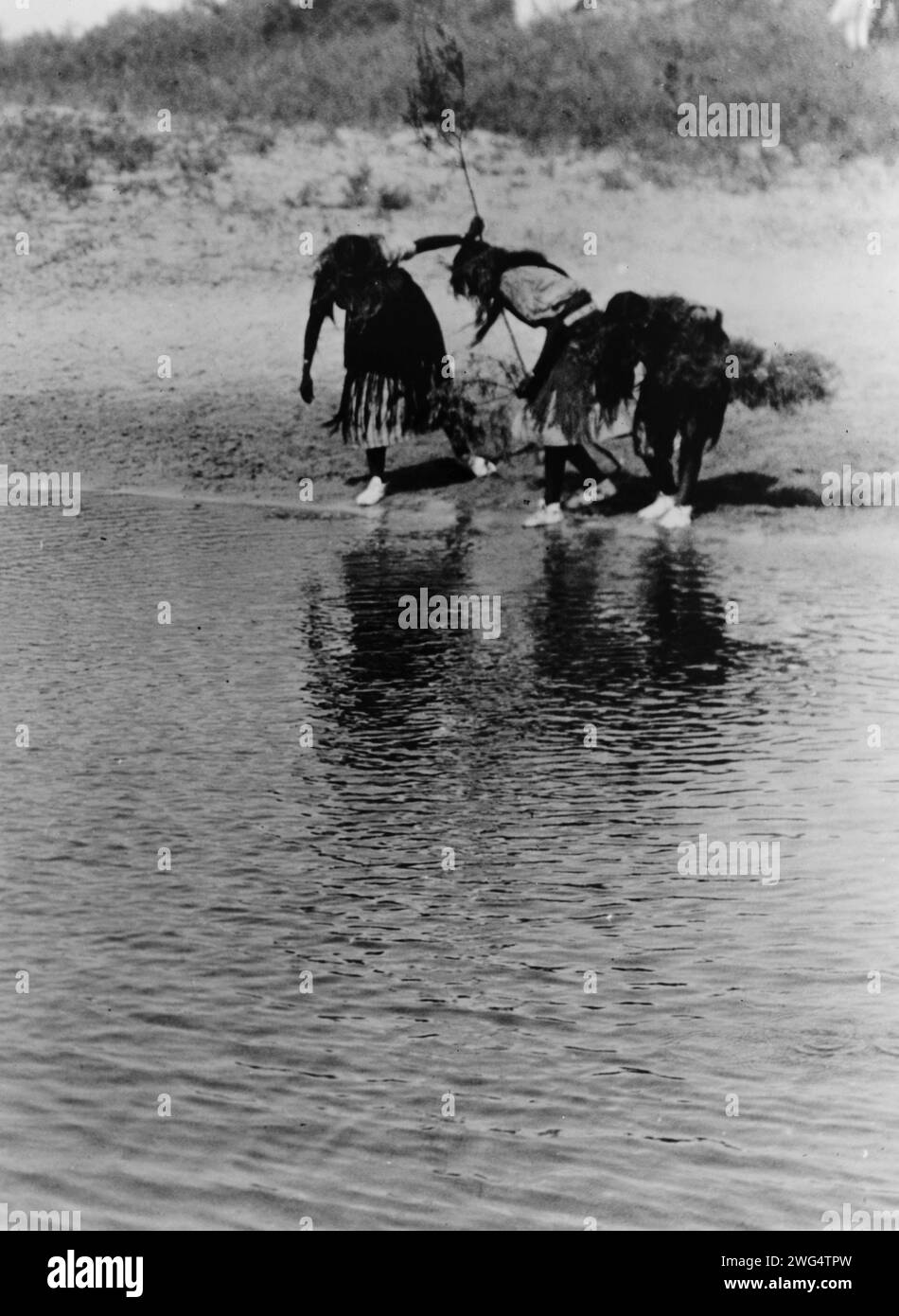 Purificazione del rito dell'acqua, danza animale Cheyenne, c1927. Tre ballerini Cheyenne in abito cerimoniale, si piegano verso l'acqua. Foto Stock