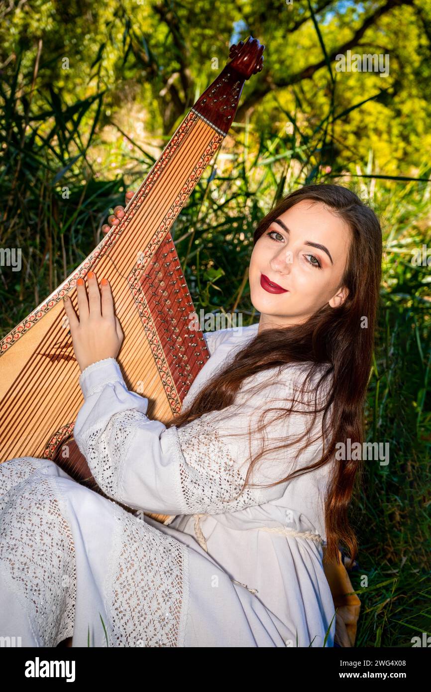 Un giocatore di bandura gioca con la bandura in una giornata estiva di sole Foto Stock