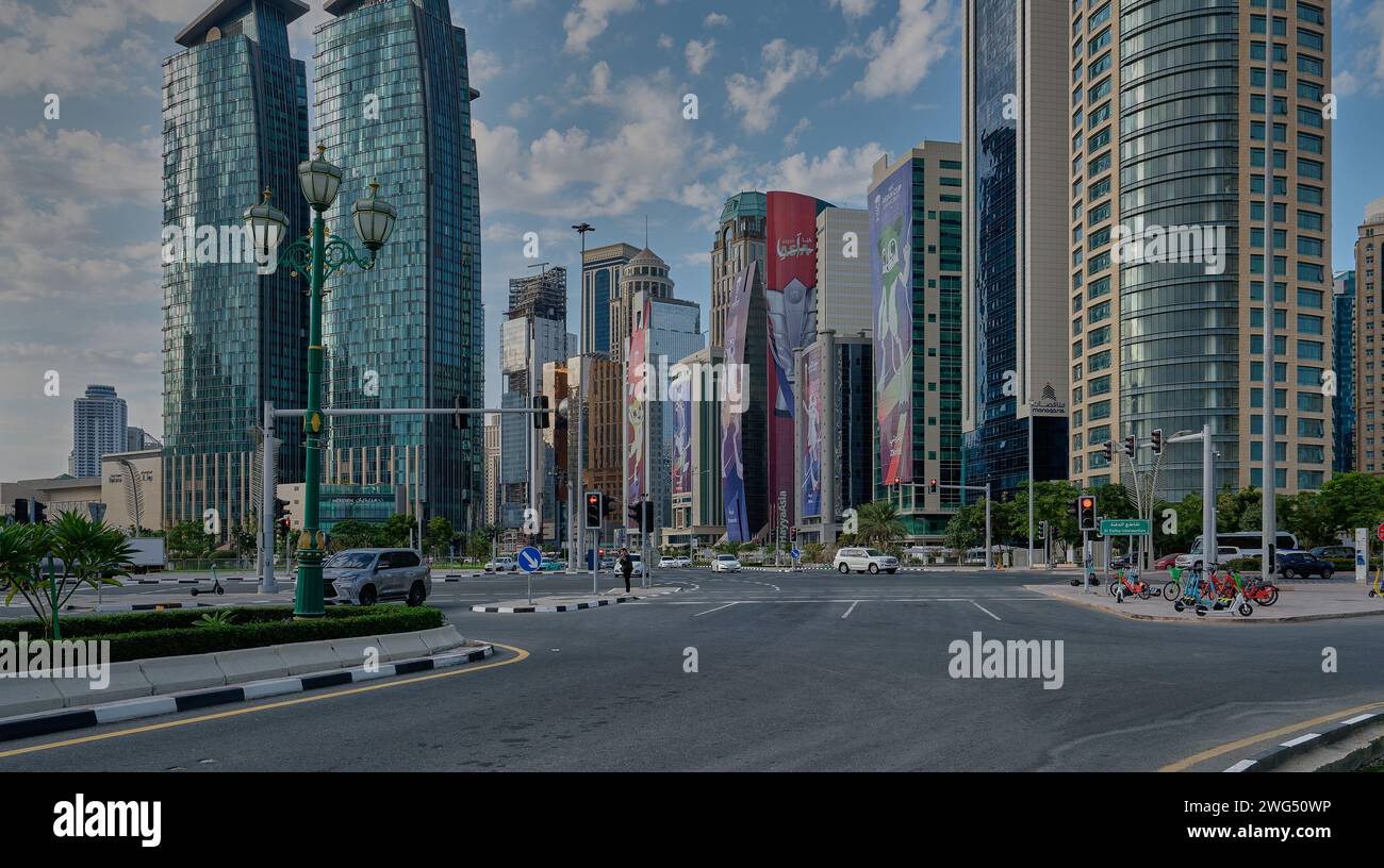 Skyline di Doha nel quartiere della West Bay Doha, Qatar pomeriggio girato con le mascotte della Coppa d'Asia 2023 AFC sugli edifici e le nuvole nel cielo Foto Stock