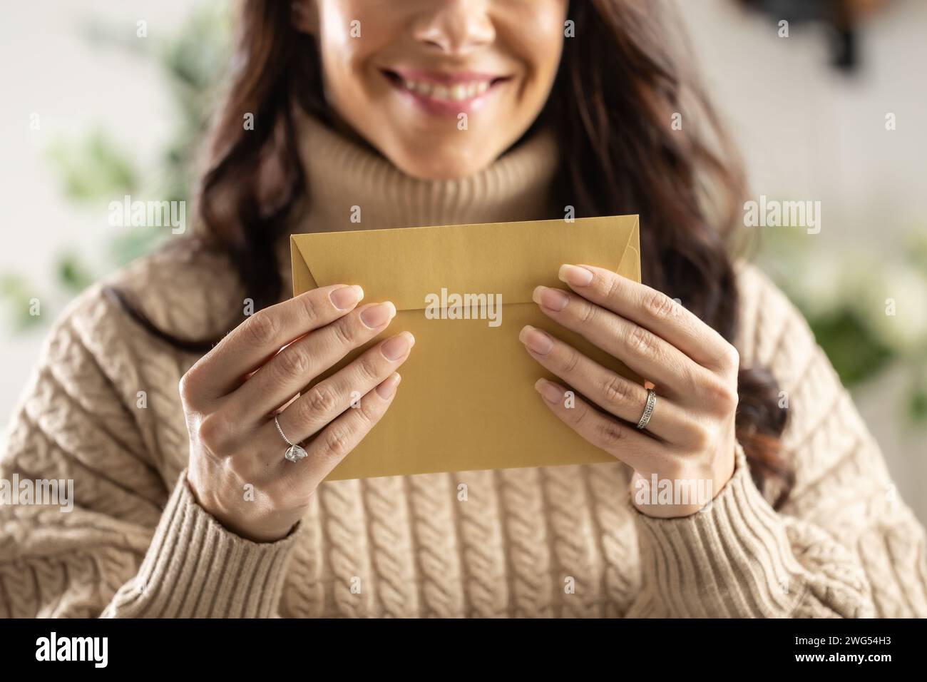 Una giovane donna sorridente tiene in mano una busta di carta riciclata. Foto Stock