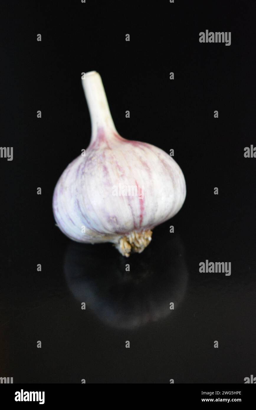 Verdure fresche, tre teste di vitello adagiate su una superficie nera lucida con riflessi ripetuti. Foto Stock