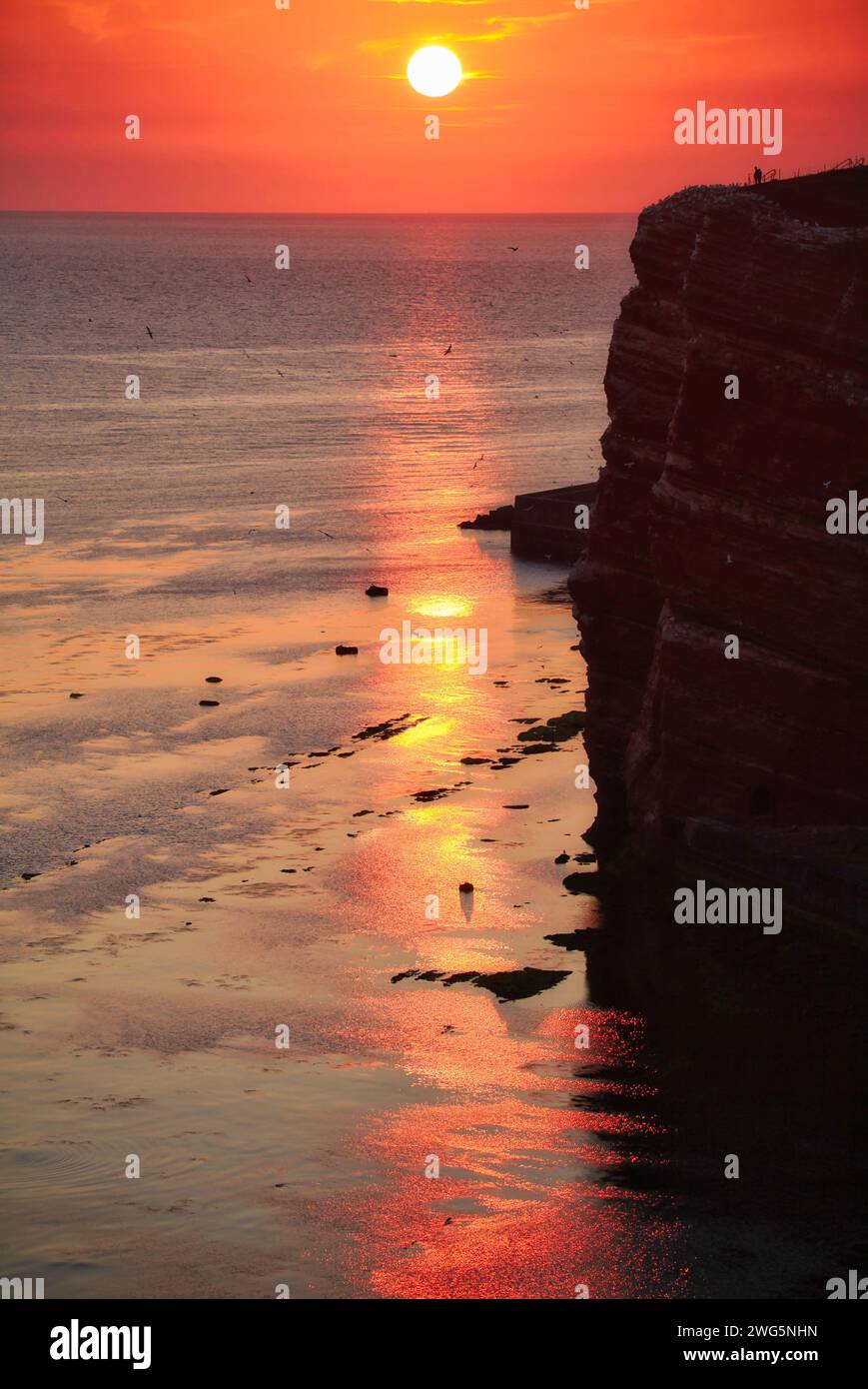 tramonto sulla costa dell'helgoland con turisti in secondo piano Foto Stock