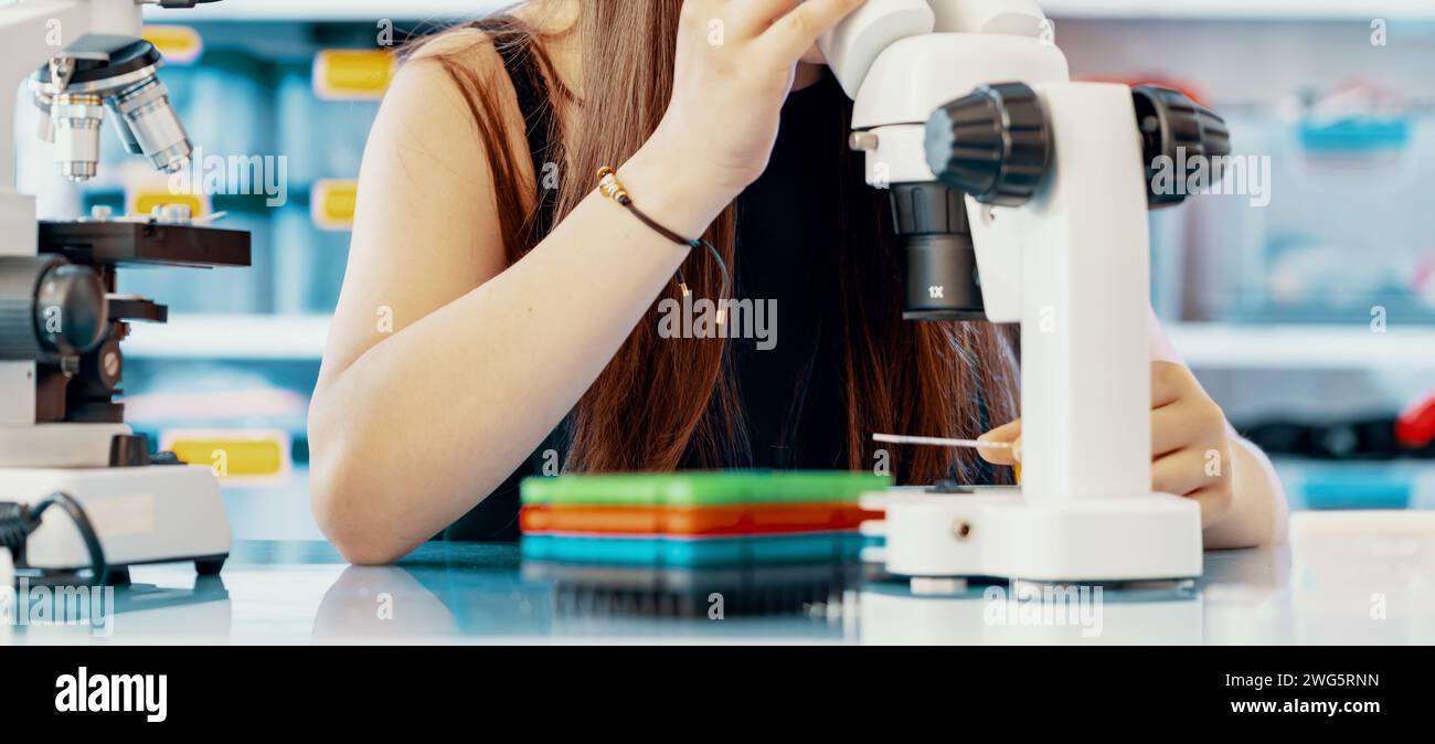 Giovane scienziata che conduce esperimenti scientifici in laboratorio Foto Stock