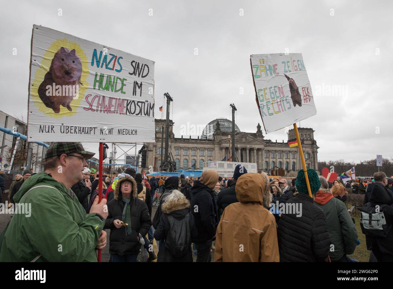 Berlino fu testimone di un monumentale raduno il 3 febbraio 2024, quando circa 300.000 manifestanti formarono un simbolico "firewall" contro l'estremismo di destra davanti al Bundestag sotto la bandiera WeAreTheFirewall. Questa massiccia mobilitazione risponde ai crescenti sentimenti di destra e alle violazioni dei diritti umani all'interno della società e della politica, sostenendo una maggiore tolleranza e una democrazia solida. Il raduno è stato organizzato dalla rete "mano in mano", che ha visto oltre 1.700 organizzazioni firmare una dichiarazione contro l'estremismo di destra, mostrando un fronte unito da un ampio spettro Foto Stock
