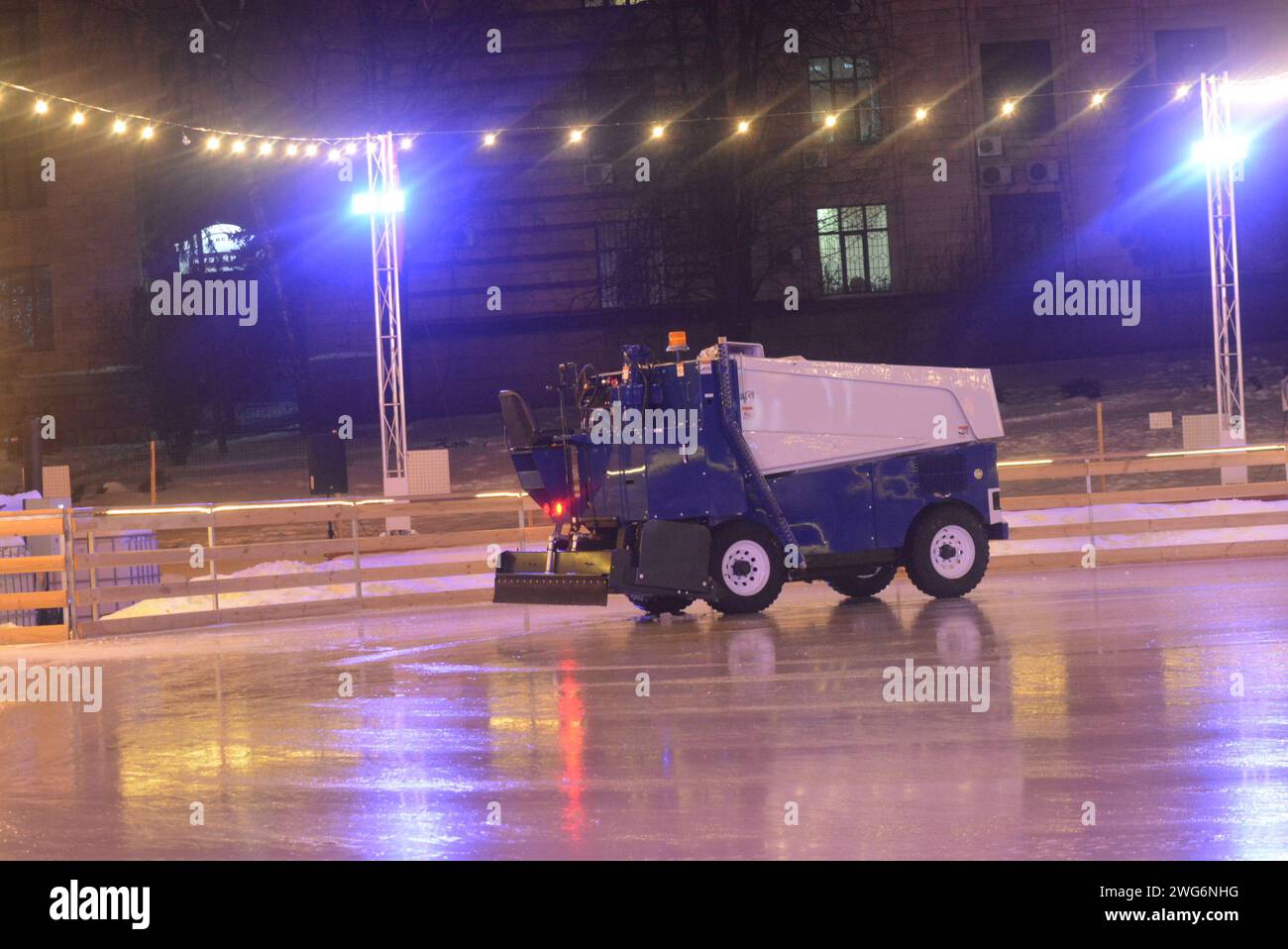 Macchina per il ghiaccio sulla pista di pattinaggio nel centro della città, dopo aver pattinato con ghiaccio liscio. Foto Stock