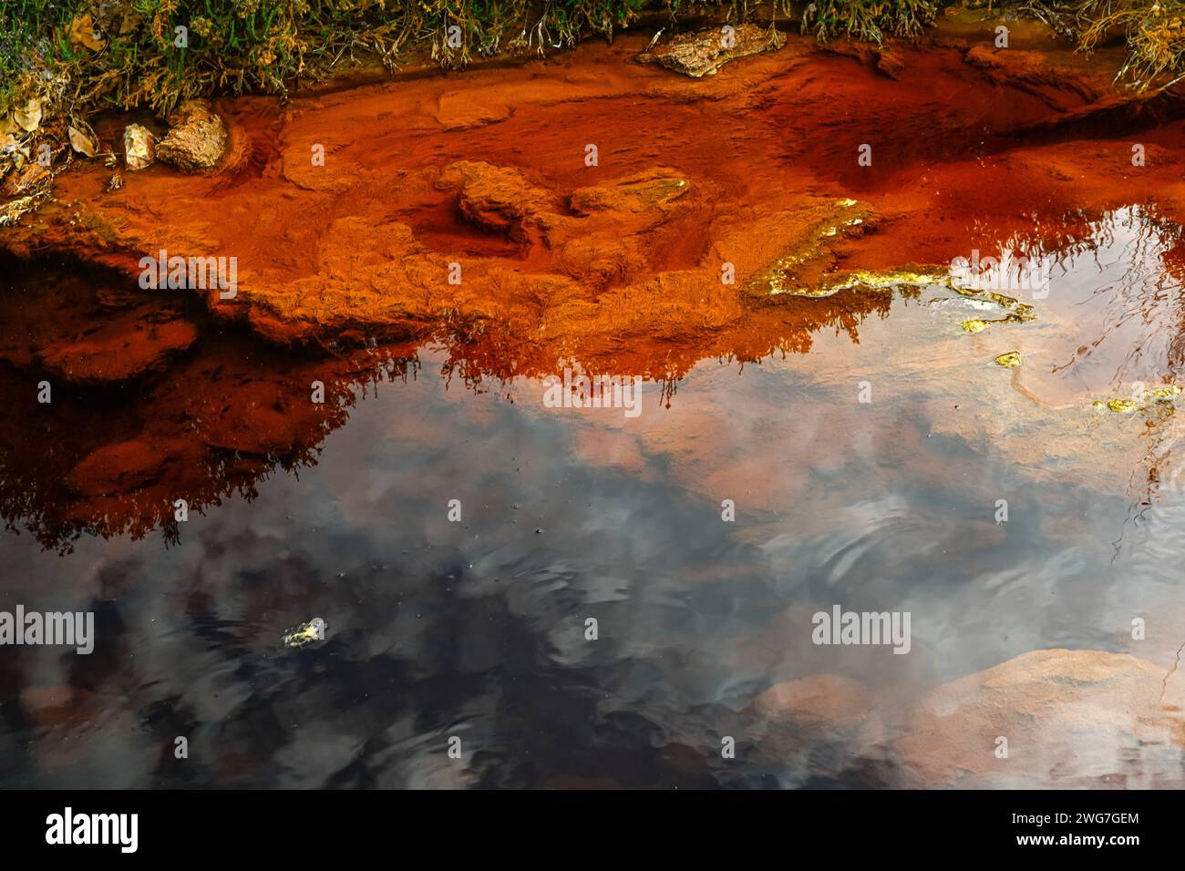 Il Rio Tinto a Huelva, Spagna, espone notevoli depositi di ferro rossi e arancioni e tracce di microrganismi verdi Foto Stock