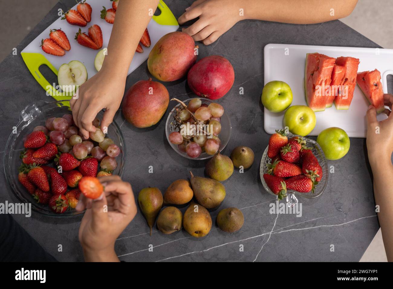 condivisione di cibo, tavola con mele, pere, fragole, anguria e uva, ingredienti per una dieta sana, stile di vita, carta da parati studio Foto Stock