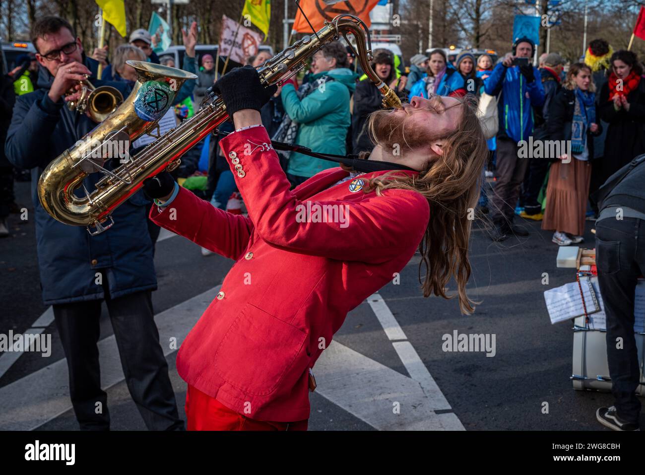 Den Haag, Olanda meridionale, Paesi Bassi. 3 febbraio 2024. Un attivista del clima suona un sassofono nel mezzo del blocco dell'autostrada A12. Il 3 febbraio 2024, gli attivisti per il clima hanno bloccato l'autostrada A12 a Den Haag, nei Paesi Bassi. La richiesta di questa dimostrazione fu la fine dei sussidi per i combustibili fossili da parte del governo olandese. (Immagine di credito: © James Petermeier/ZUMA Press Wire) SOLO USO EDITORIALE! Non per USO commerciale! Crediti: ZUMA Press, Inc./Alamy Live News Foto Stock