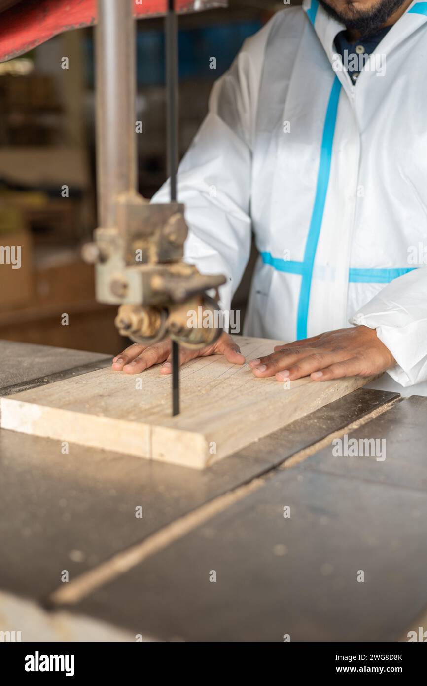dettagli della lavorazione del legno, mani di una persona che effettua un taglio con una sega, occupazione di carpenteria e utensili industriali, lavori artigianali Foto Stock