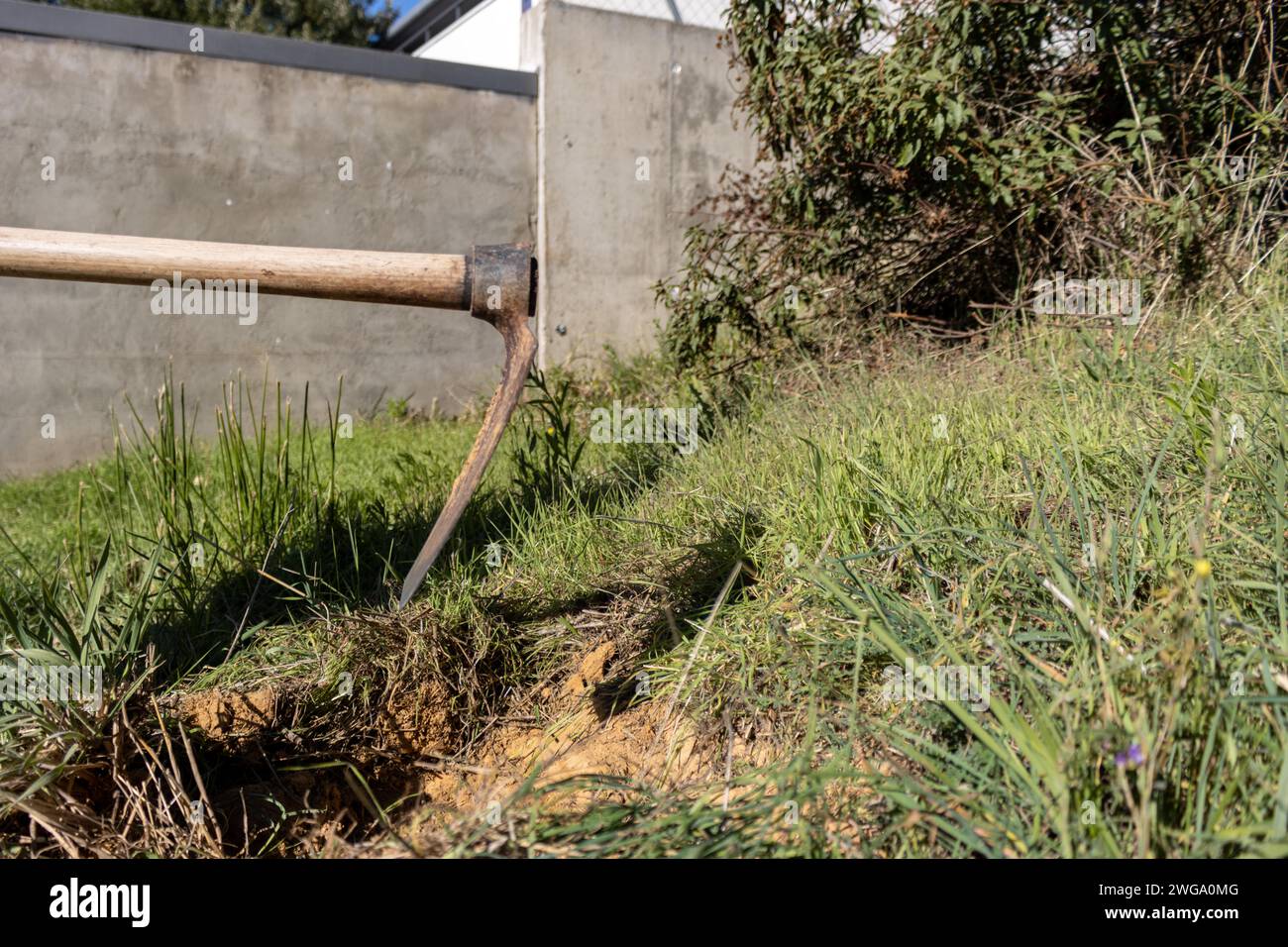 Foto dettagliata di una zappa che scava il terreno di un giardino per la piantagione Foto Stock