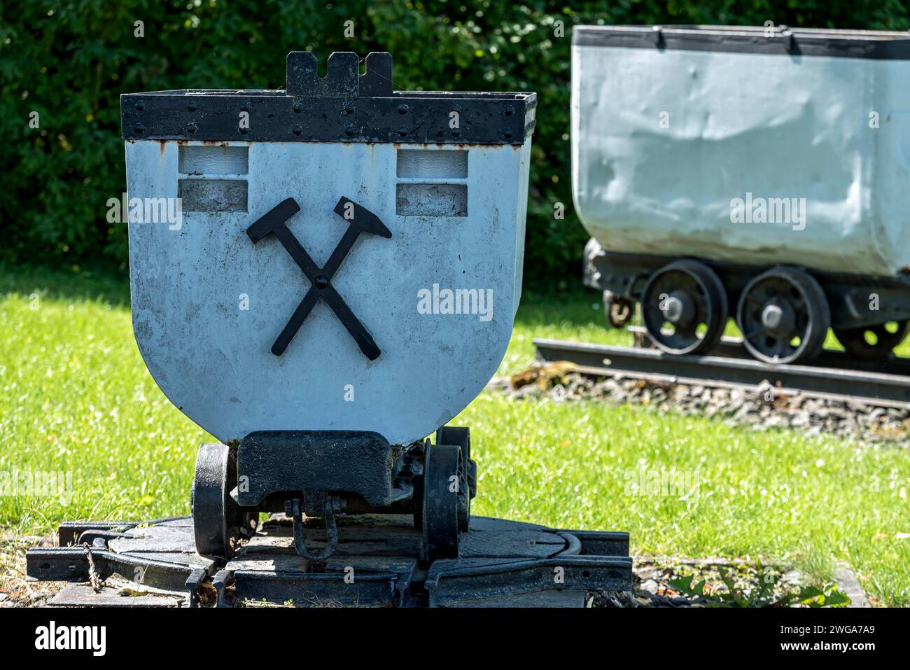 Carrelli per il trasporto sotterraneo di lignite, miniere, vagone con simbolo di martello e ferro, carro, museo all'aperto sulla ferrovia di Weckesheim Foto Stock