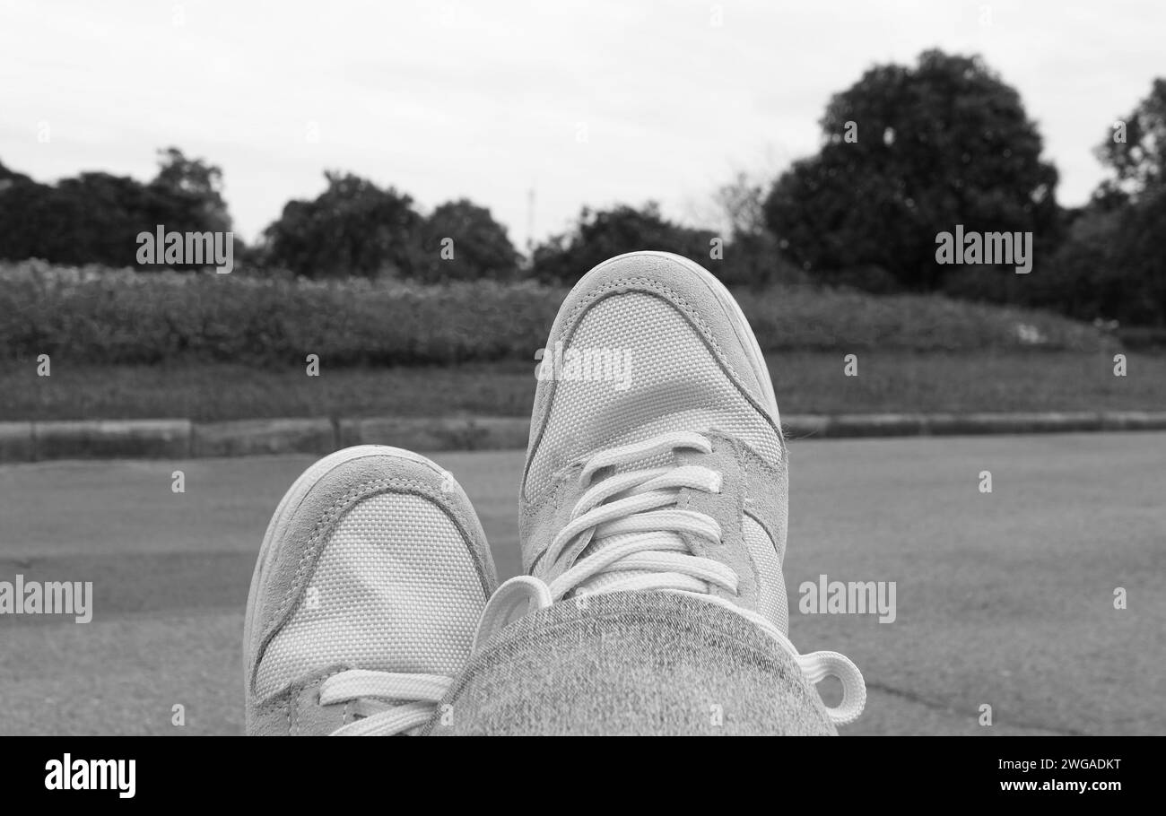 Immagine monocromatica di persone che rilassano i piedi nel giardino Foto Stock