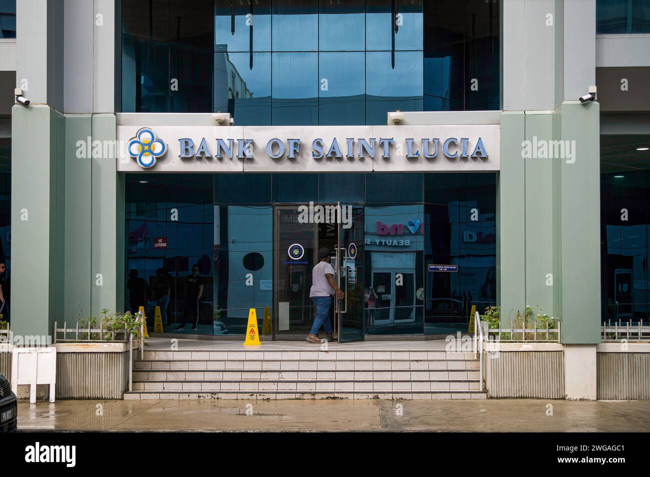 Una persona che entra nell'edificio della Banca di Santa Lucia, la principale istituzione finanziaria di Castries, St. Lucia, gennaio 2024. Foto Stock