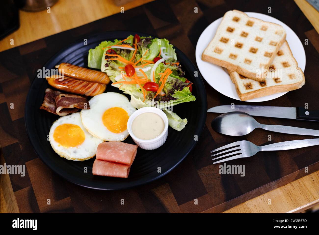 Colazione completa con uova fritte, salsiccia, pancetta, prosciutto, pane tostato e insalata. Vista dall'alto Foto Stock