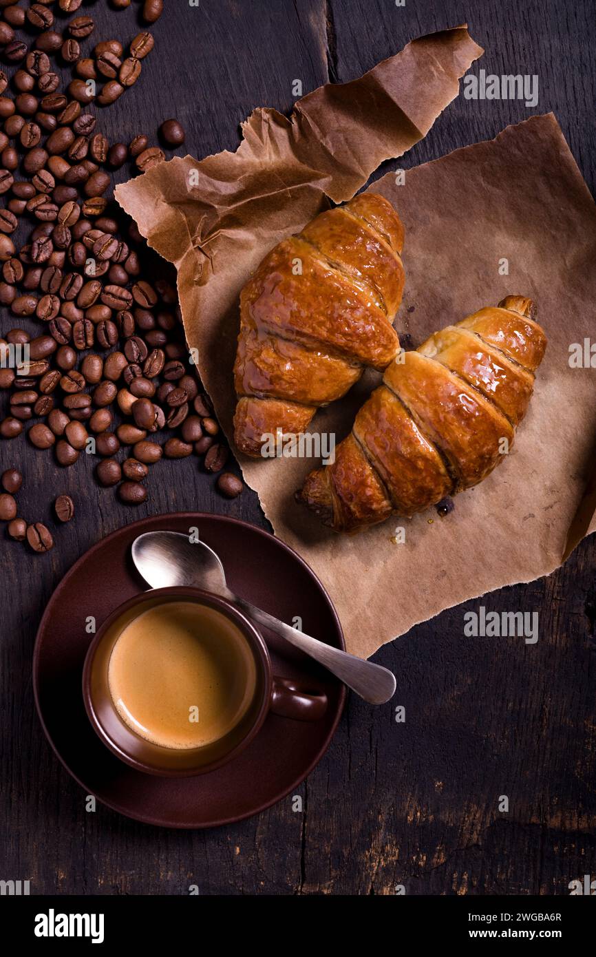 colazione fatta in casa con espresso, croissant caldi su un tavolo rustico in legno. vista dall'alto, Foto Stock