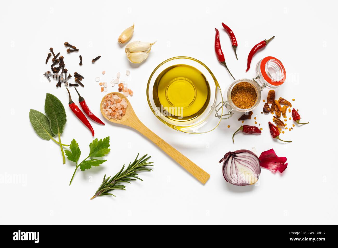 varietà di erbe e spezie, una ciotola con olio d'oliva è disposta su sfondo bianco. vista dall'alto Foto Stock