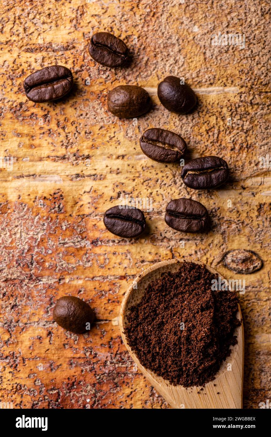 in primo piano, dall'alto, dei chicchi di caffè e del caffè in polvere nel cucchiaio. Foto Stock