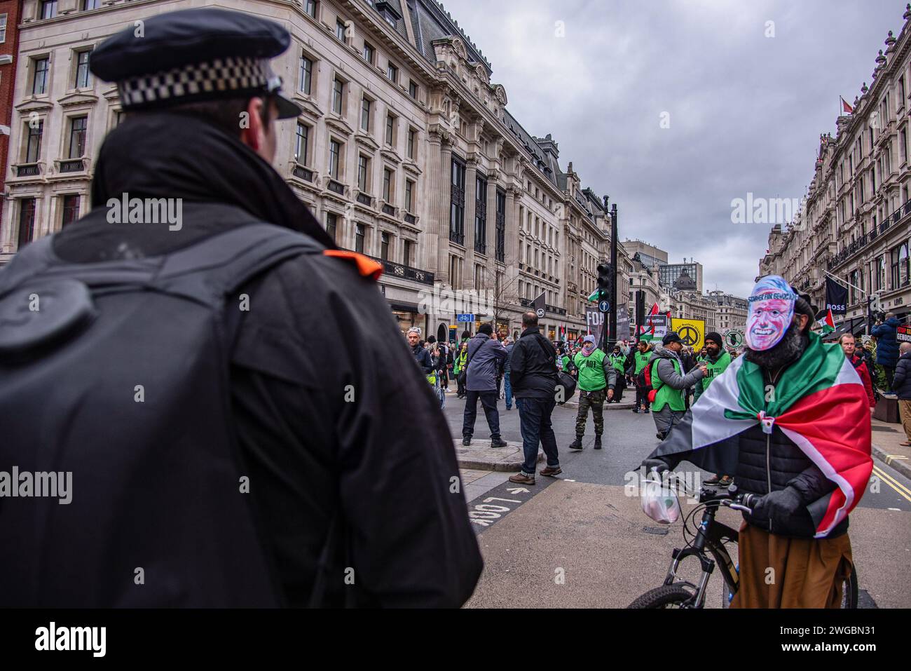 Londra, Regno Unito. 3 febbraio 2024. Un manifestante mascherato parla con la polizia durante la marcia nazionale per la Palestina: Cessate il fuoco ora!. La campagna di solidarietà della Palestina ha organizzato una marcia per la Palestina per un cessate il fuoco e per fermare il genocidio a Gaza. Israele ha ucciso oltre 25.000 palestinesi nel suo brutale attacco a Gaza e altre migliaia sono sotto le macerie. Credito: SOPA Images Limited/Alamy Live News Foto Stock