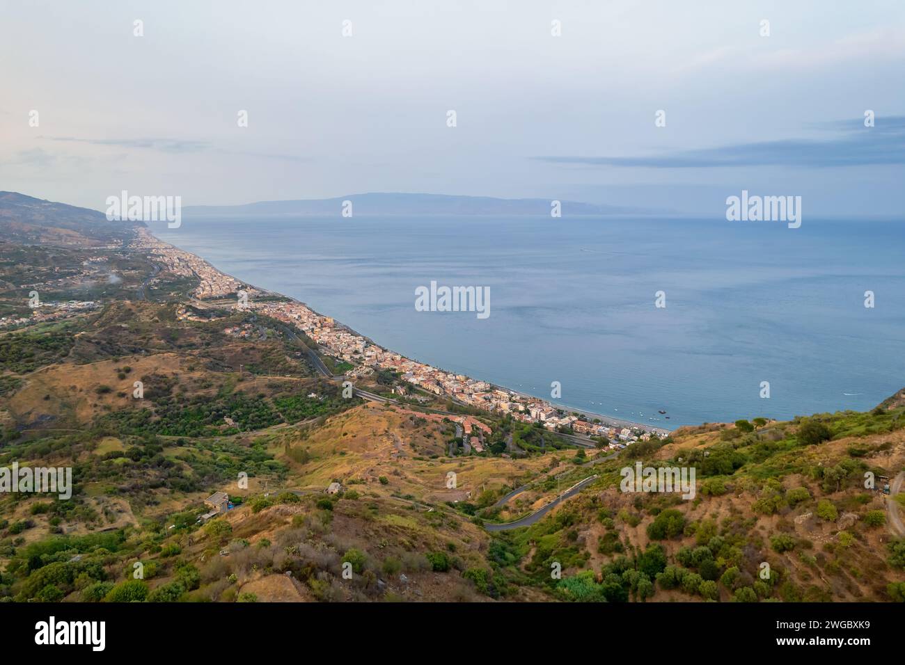 Vista aerea del paesaggio costiero del villaggio da Taormina con la Calabria in lontananza, Sicilia, Italia Foto Stock