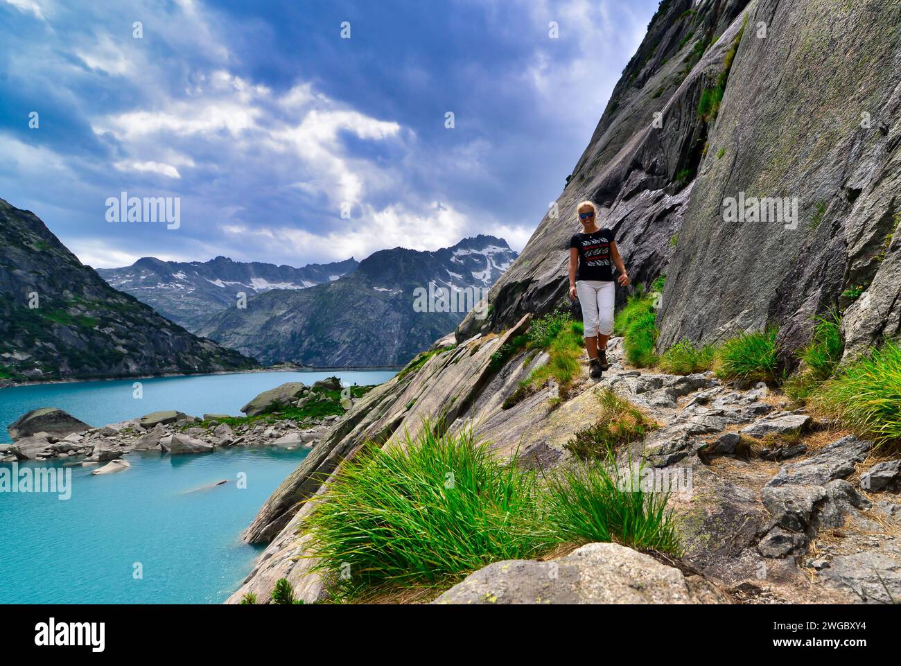 Donna che cammina lungo il lago di Gelmersee (lago Gelmer), Oberland Bernese, Svizzera Foto Stock