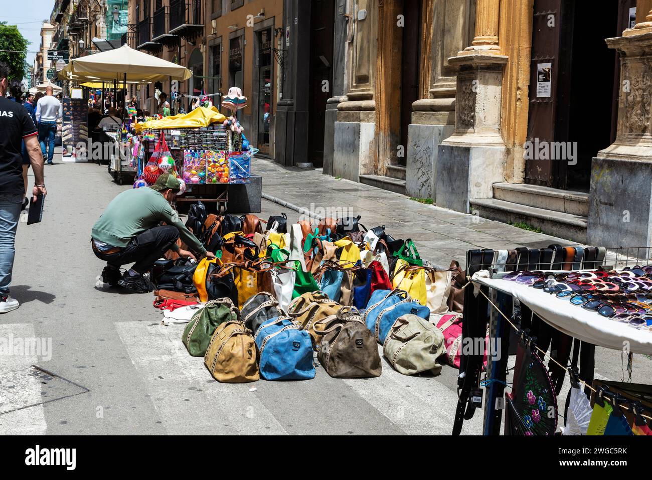 Palermo, Italia - 13 maggio 2023: Venditore al suo banco che vende borse, borse, vestiti e occhiali da sole in una via dello shopping via Maqueda a Palermo, Sicilia, i Foto Stock
