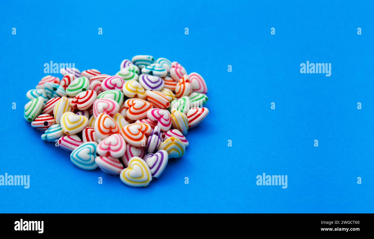 Cuore formato con perline dalle linee colorate per realizzare collane e bracciali Foto Stock