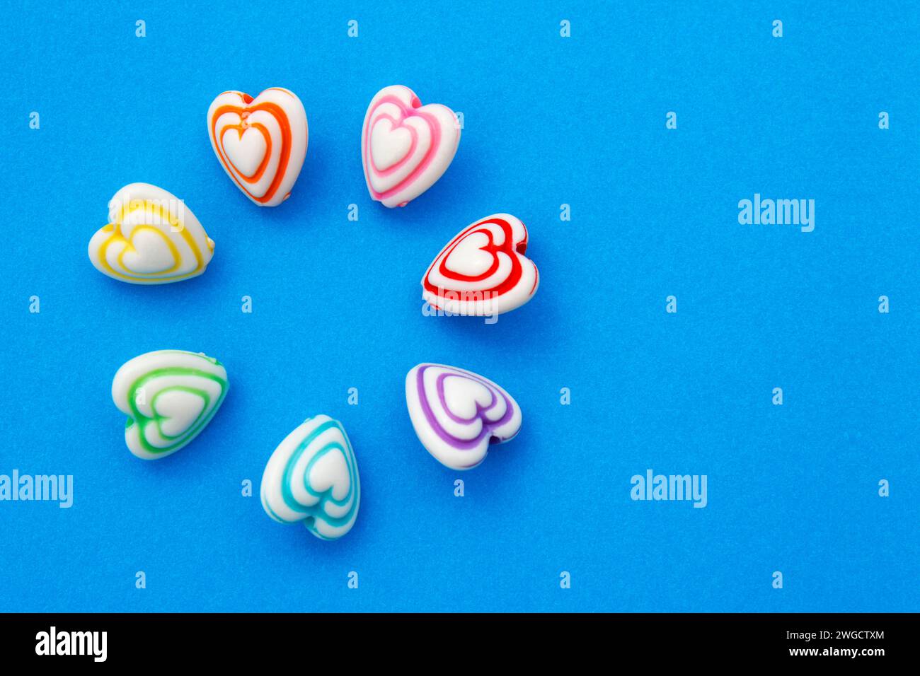Cerchio di cuori, perline con linee colorate per realizzare collane e bracciali Foto Stock