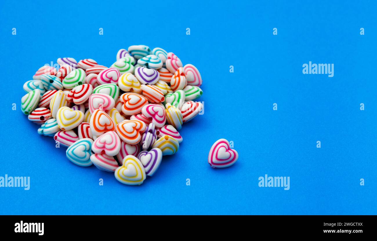 Perline con linee colorate e forma a cuore per realizzare collane e bracciali Foto Stock