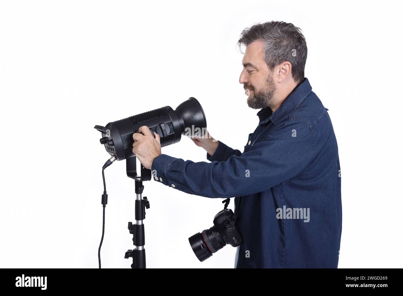 Fotografo che controlla la luce in studio, foto con vista laterale ravvicinata. lavoro, professione Foto Stock