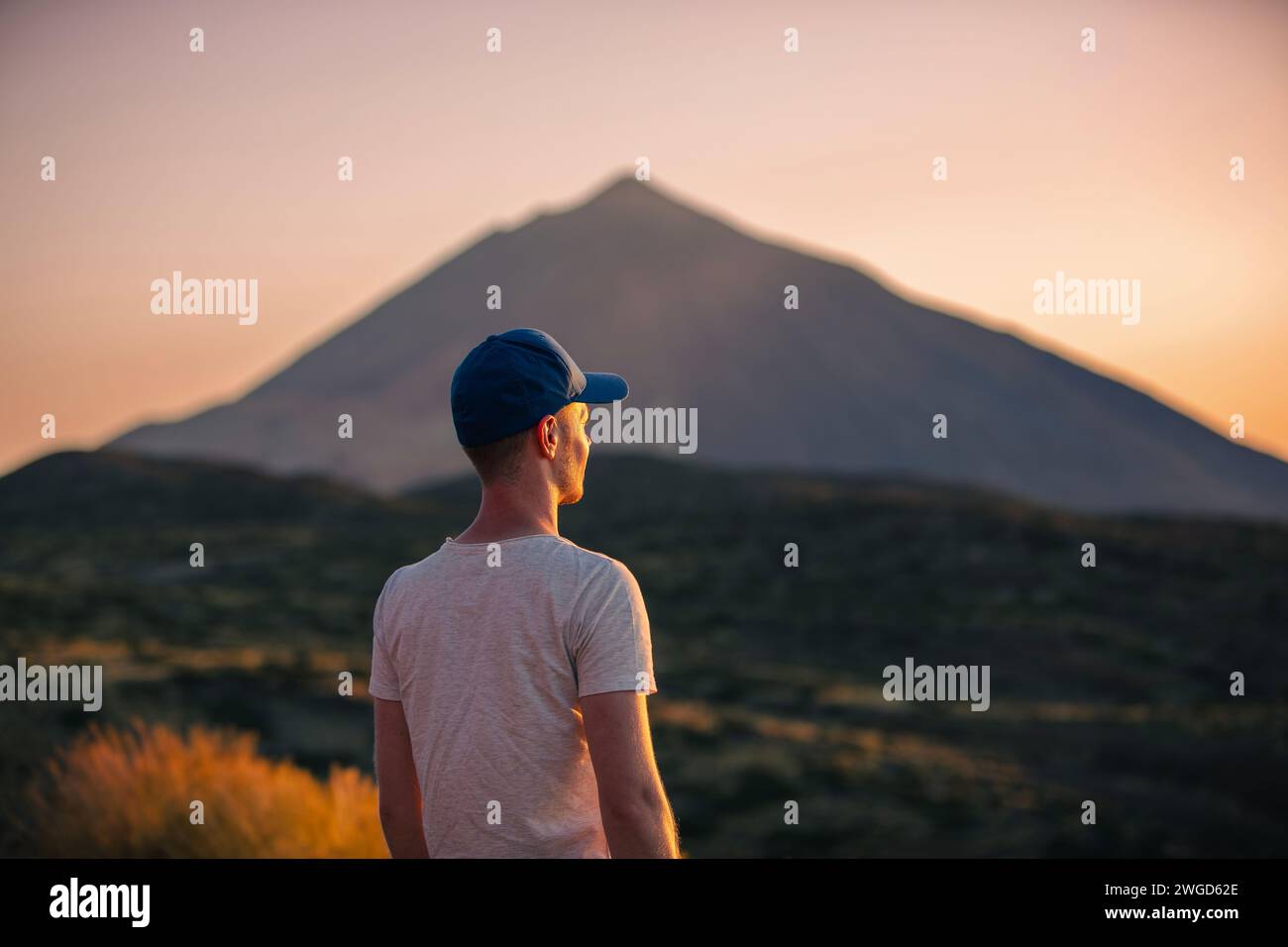 L'uomo che guarda il paesaggio con il vulcano Teide al tramonto. Turista durante l'escursione sull'isola di Tenerife delle Canarie. Foto Stock
