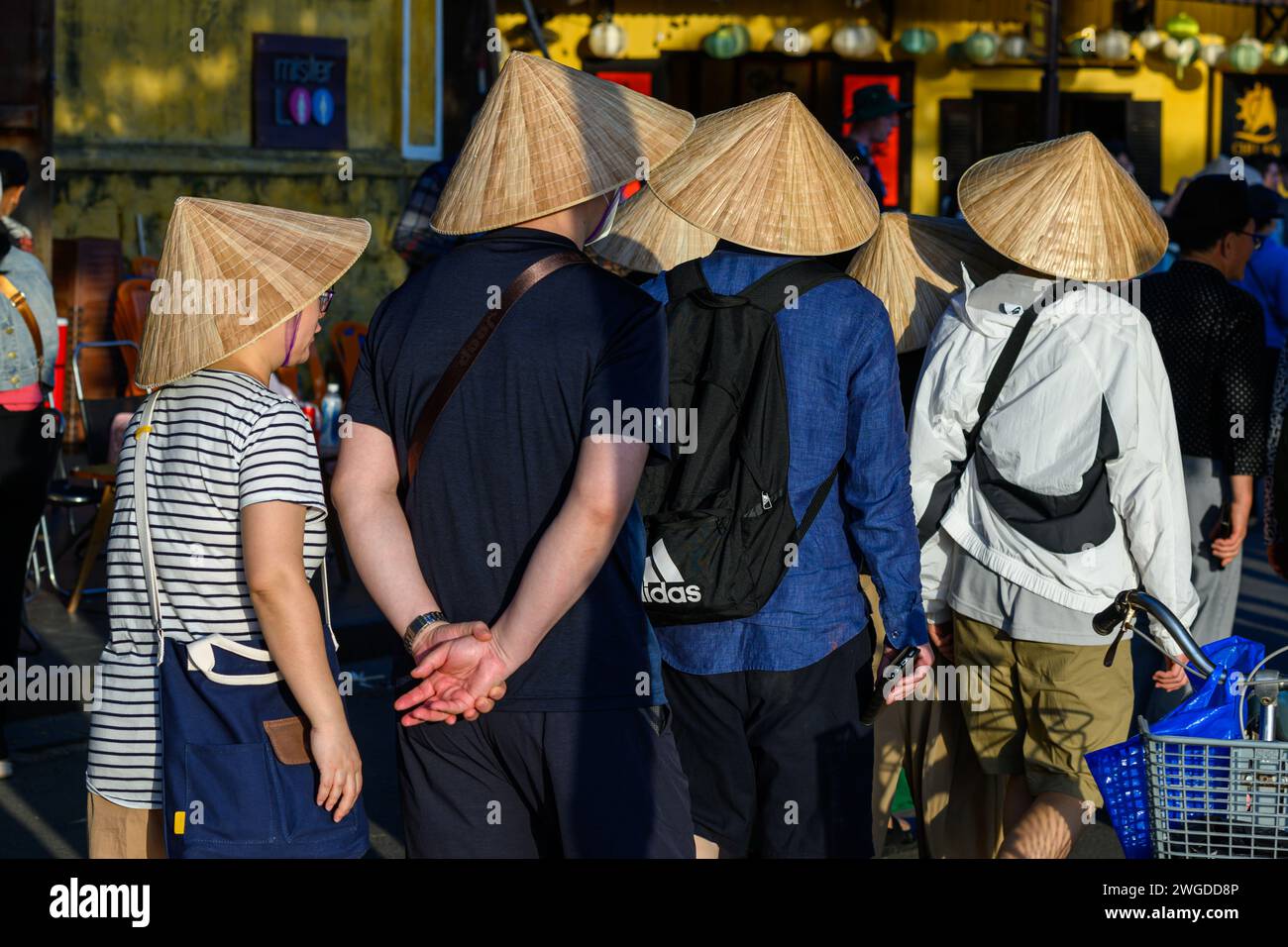 Turisti che indossano cappelli conici a Hoi An, Vietnam Foto Stock