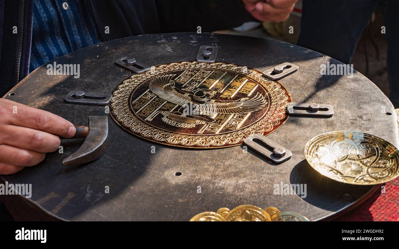 Primo piano di un artista che lavora in metallo intagliando a mano un piatto al Cairo, in Egitto Foto Stock