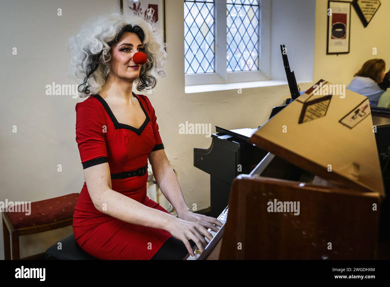 Londra, Regno Unito. 4 febbraio 2024. Il servizio inizia con un'introduzione musicale. I clown si riuniscono nei loro costumi alla Haggerston All Saints Church per il servizio Grimaldi, ora al suo 78° anno. Il servizio e l'evento circostante si svolgono ogni anno in onore del famoso intrattenitore dell'era Regency Joseph Grimaldi, e celebrano la vita dei clown della comunità che potrebbero essere morti di recente. Crediti: Imageplotter/Alamy Live News Foto Stock