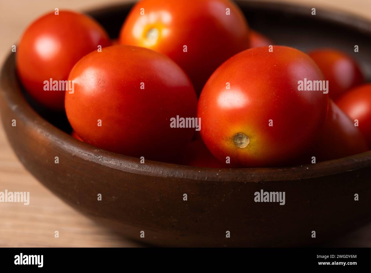 pomodori prugna in un piatto di argilla sul tavolo da vicino Foto Stock