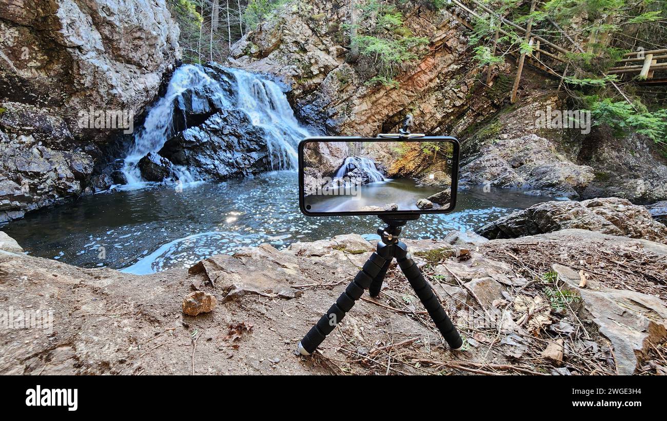 Un piccolo treppiede che cattura la cascata nella foresta Foto Stock