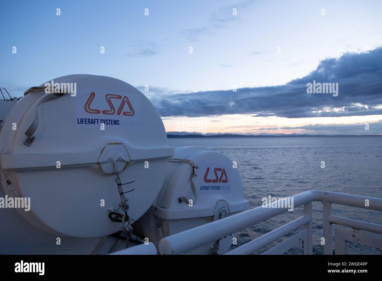 ISOLA DI VANCOUVER, BC, CANADA - 1 GIUGNO 2023: Sistema di zattere di salvataggio sul ponte di un traghetto con vista sull'oceano al tramonto, sicurezza della barca, salvataggio, sicurezza marina Foto Stock