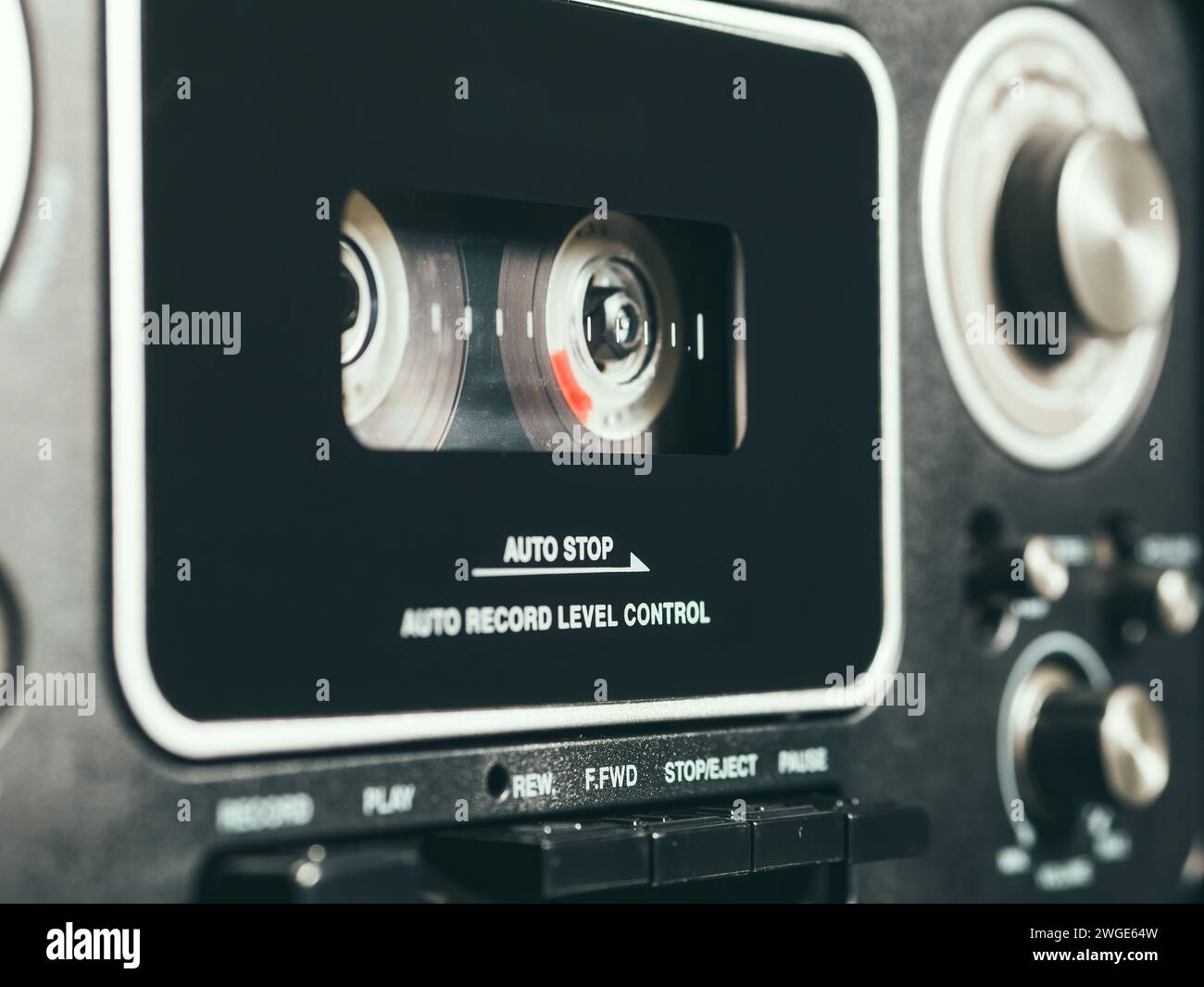 Primo piano con un nastro audio in un lettore musicale retrò. Foto Stock