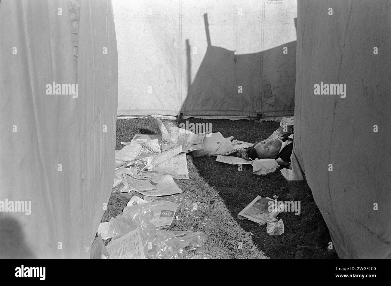 uomo ubriaco degli anni '1970 alle corse di cavalli. Una giornata alle corse, un uomo dorme da una sbornia, è ubriaco dietro la tenda della birra al Derby, un festival annuale di corse di cavalli. Epsom Downs, Surrey, Inghilterra giugno 1970. HOMER SYKES Foto Stock